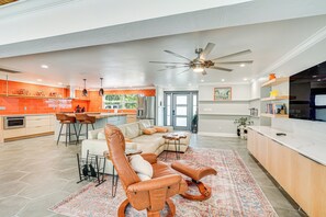 A spacious living area with a large leather sofa, a coffee table, and a ceiling fan. - Walk to Beach: Cape Coral Home w/ Grill & Patio (Cape Coral)
