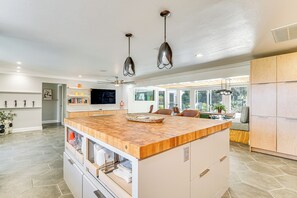 A modern kitchen with a large island, pendant lights, and a dining area with a view. - Walk to Beach: Cape Coral Home w/ Grill & Patio (Cape Coral)