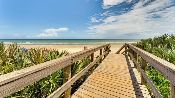 A wooden boardwalk leading to a beach with clear skies and ocean views. - New Smyrna Beach Condo w/ Balcony & Ocean Walk (New Smyrna Beach)