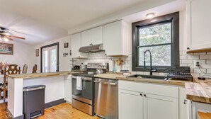 A modern kitchen with white cabinets, stainless steel appliances, a wooden countertop, and a window providing natural light. - Walk to Mohican Lake: Catskills Getaway w/ Dock! (Glen Spey)