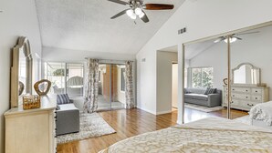 A spacious bedroom with a large bed, a ceiling fan, a wardrobe, and a mirror. - Huntington Beach Home: Fire Pit, Grill + More! (Huntington Beach)