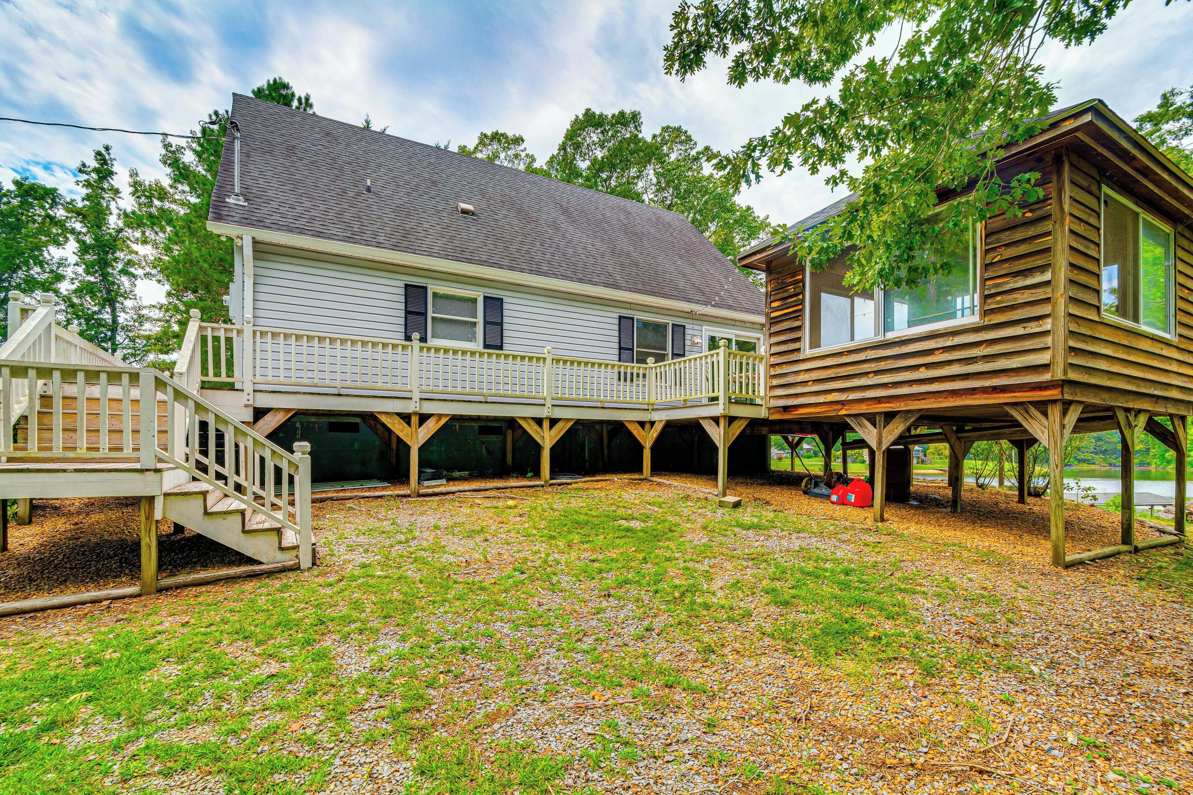A two-story house with a covered patio area and a small deck.