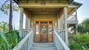 A wooden house with a porch, a welcome sign, and a staircase leading to the entrance. - Beach & Pool Access: Peaceful St Teresa House (Carrabelle)
