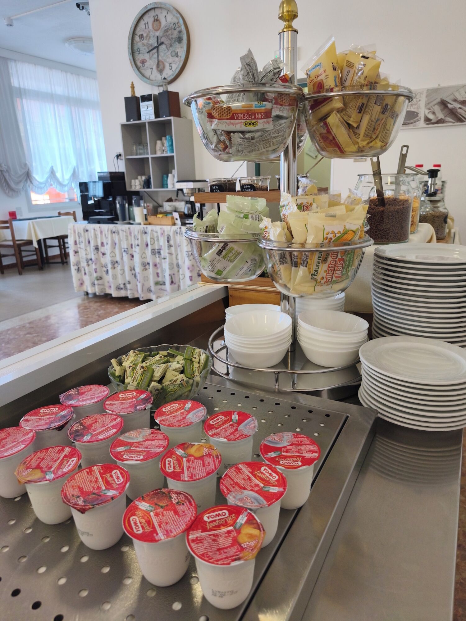 Un buffet proposant une variété de plats et de récipients, notamment des bols de p âtes, des assiettes et des pots de yaourt.