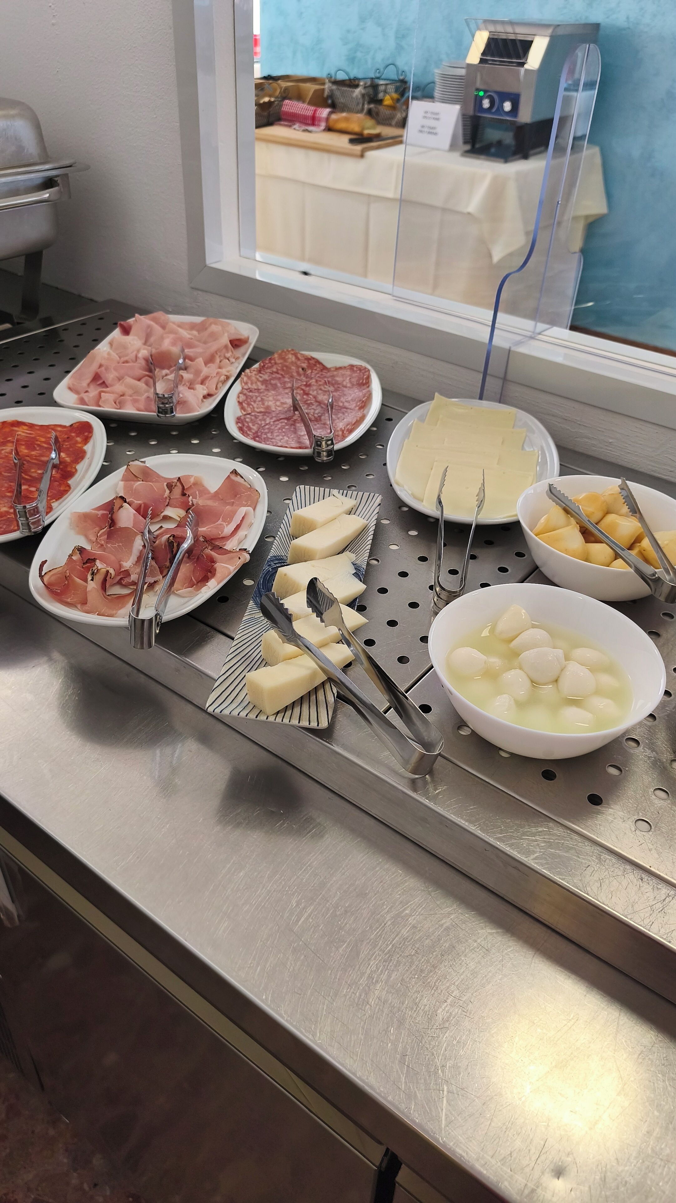 Un buffet proposant une variété de plats, notamment des viandes, des fromages et des fruits.