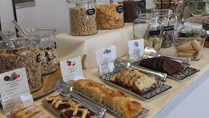 A bakery display with various baked goods and jars of ingredients. - Le Petit Hotel (Lido di Jesolo)