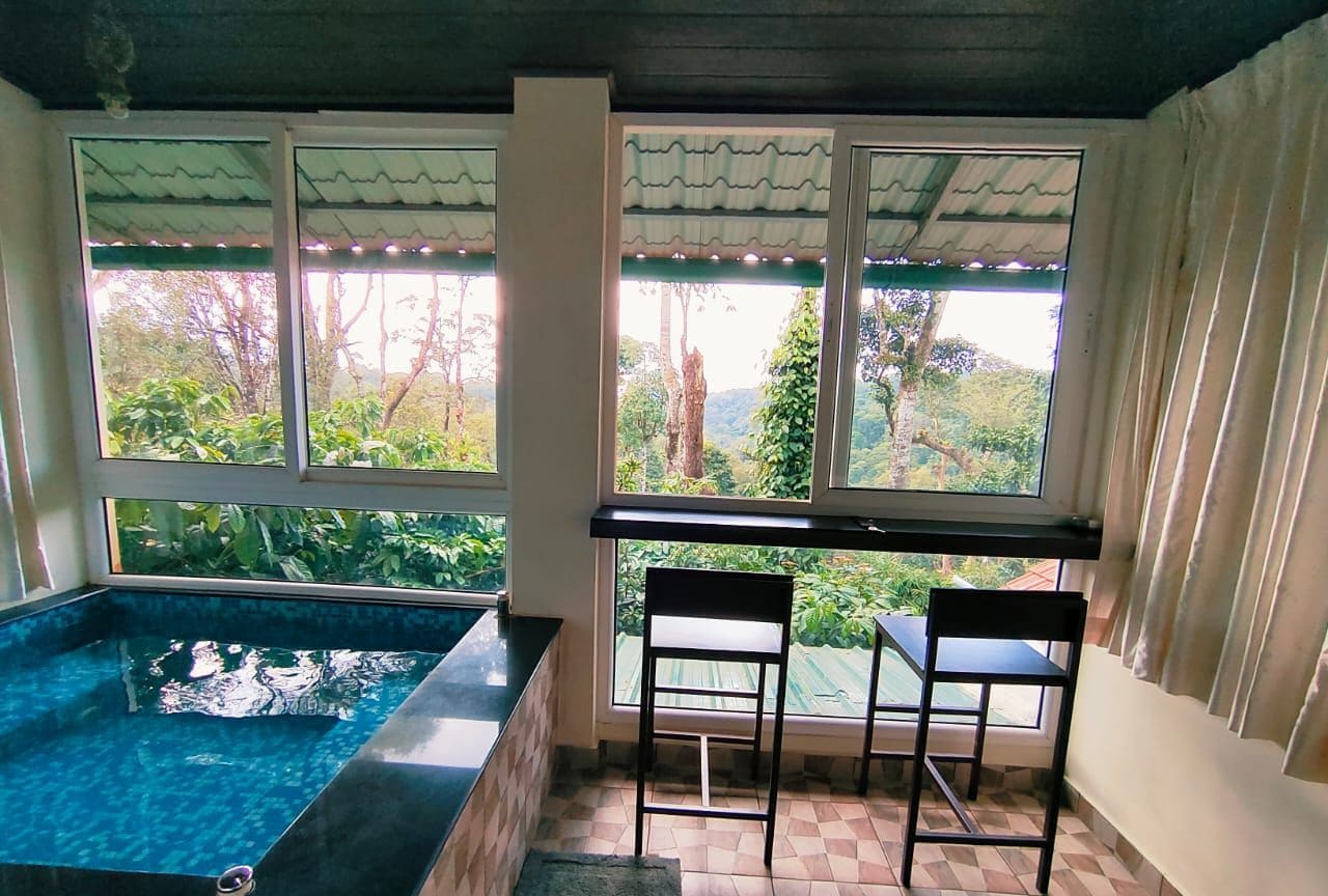 Una habitación con piscina, dos sillas y una mesa.