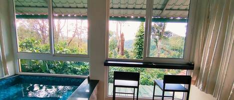 A room with a pool, two chairs, and a table.