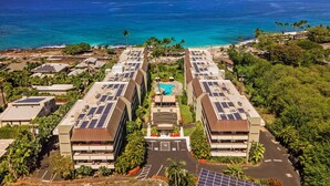 Ein Hotel mit mehreren Gebäuden, Solaranlagen auf den Dächern, einem Schwimmbad und Blick auf den Ozean.