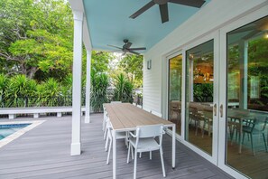 A covered patio with a pool, a table and chairs, and a ceiling fan. - The Rigby House - Pool, One block from Duval St (Key West)