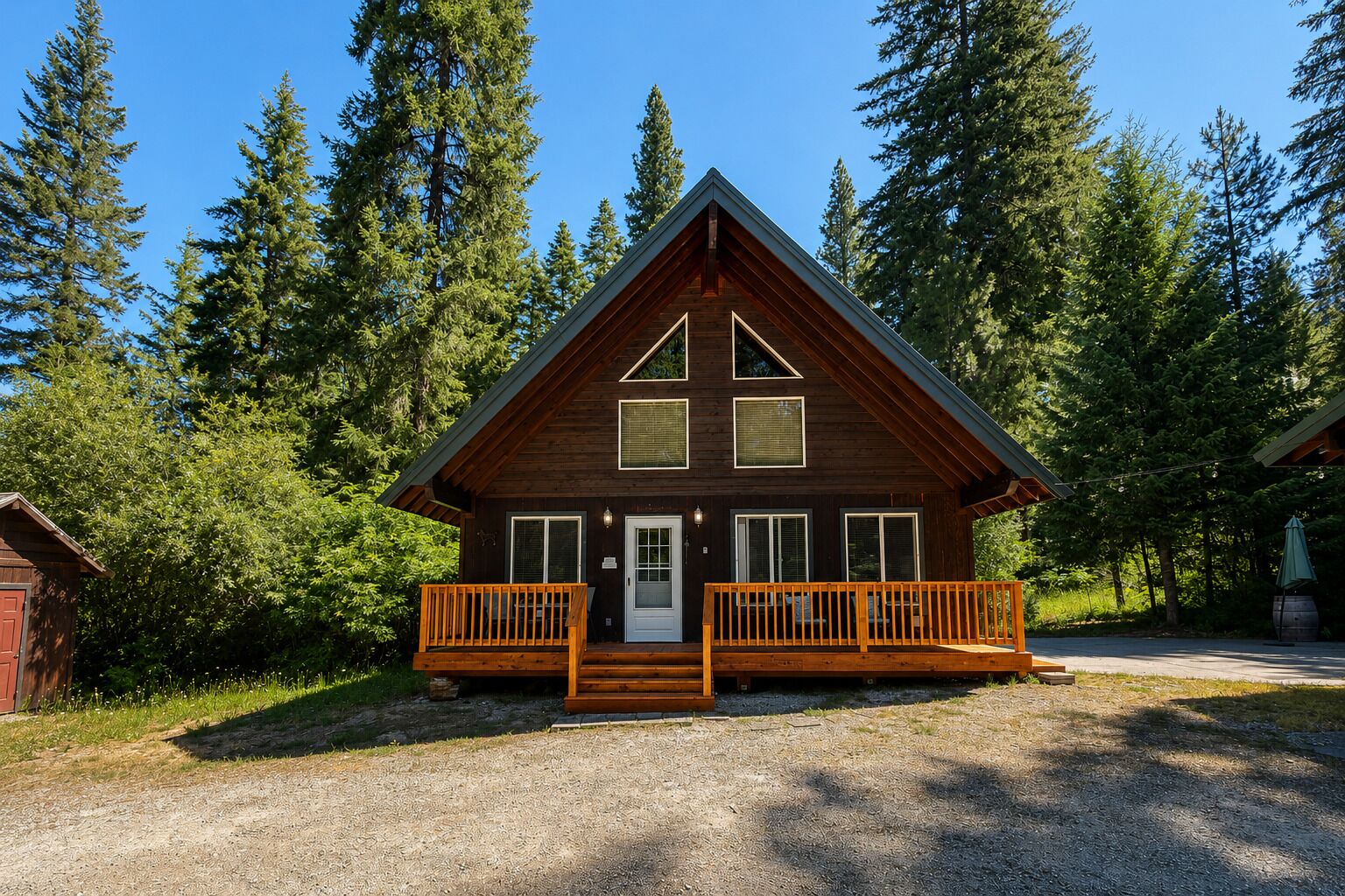 Une cabane avec un porche à l’avant, une porte et des fenêtres.