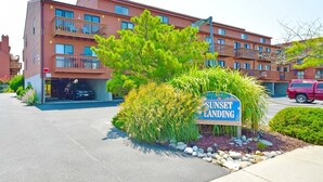 A multi-story building with balconies and a sign reading "Sunset Landing". - Sunset Landing 24 2 Bedroom Townhouse by RedAwning (Ocean City)