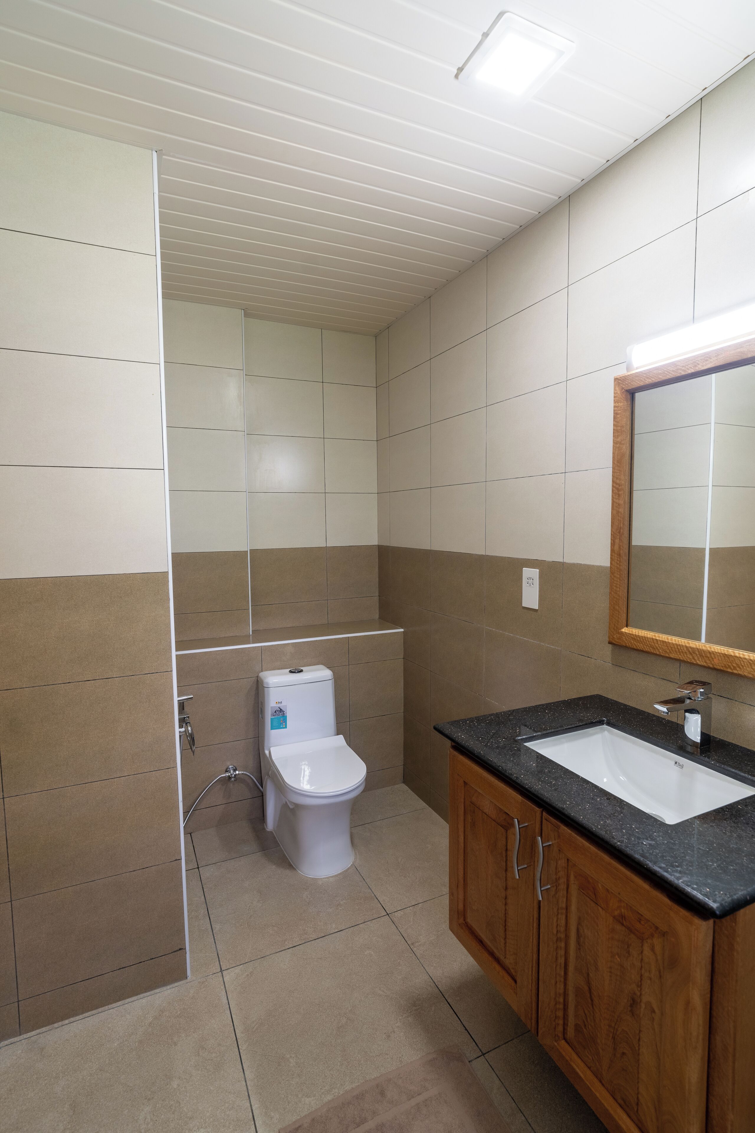 A bathroom with a toilet, sink, and mirror.