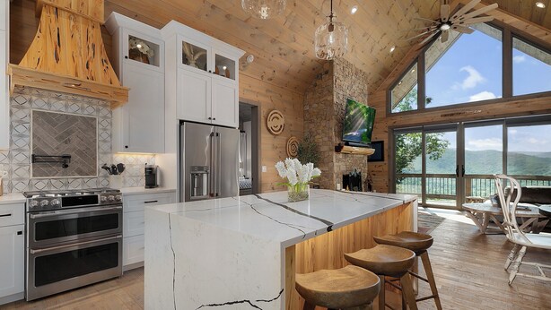 A modern kitchen with a large island, stainless steel appliances, and a view of the outdoors. - Elevated Escape Blue Ridge GA (Blue Ridge)