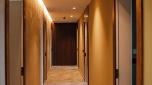 A long, narrow hallway with a tiled floor and wooden walls. - Hotel Flaer (Shkodër)
