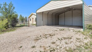 A covered outdoor storage area with a gravel floor and metal fencing. - Peggy s View - Uplifting Cozy Mountain Views (Alpine)