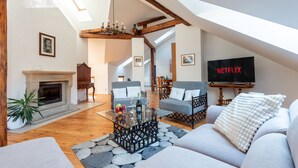A spacious living room with a fireplace, a glass coffee table, and a comfortable seating area. - Spacious 2-level apart National Theatre (Prague)