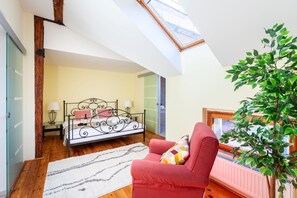 Relax in this serene bedroom with a plush armchair, bedside table, and a comfortable bed.