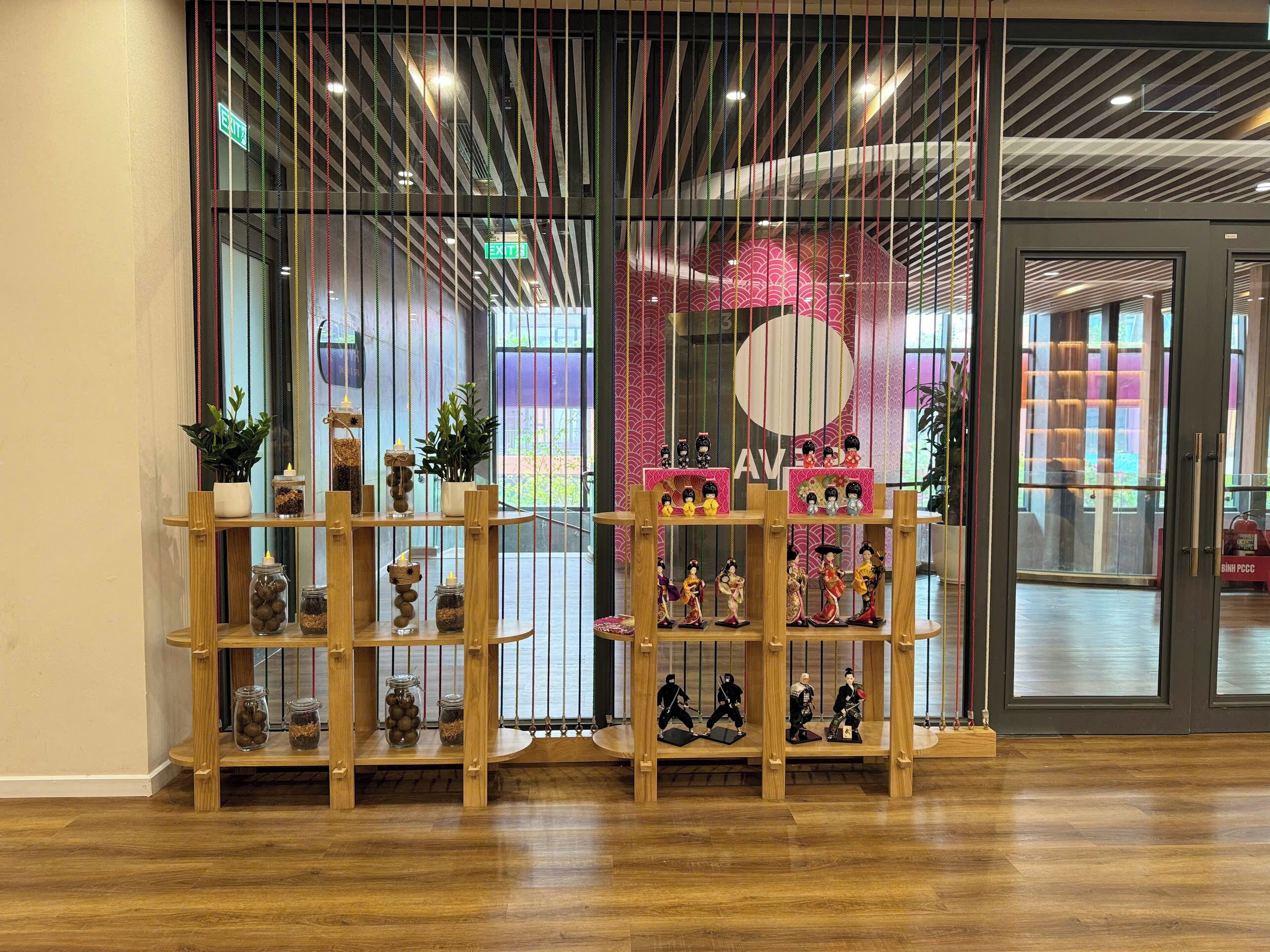 A traditional Japanese interior with wooden shelves displaying various items, a large circular design on the wall, and an exit sign.