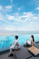 Una piscina techada, una piscina al aire libre, sombrillas