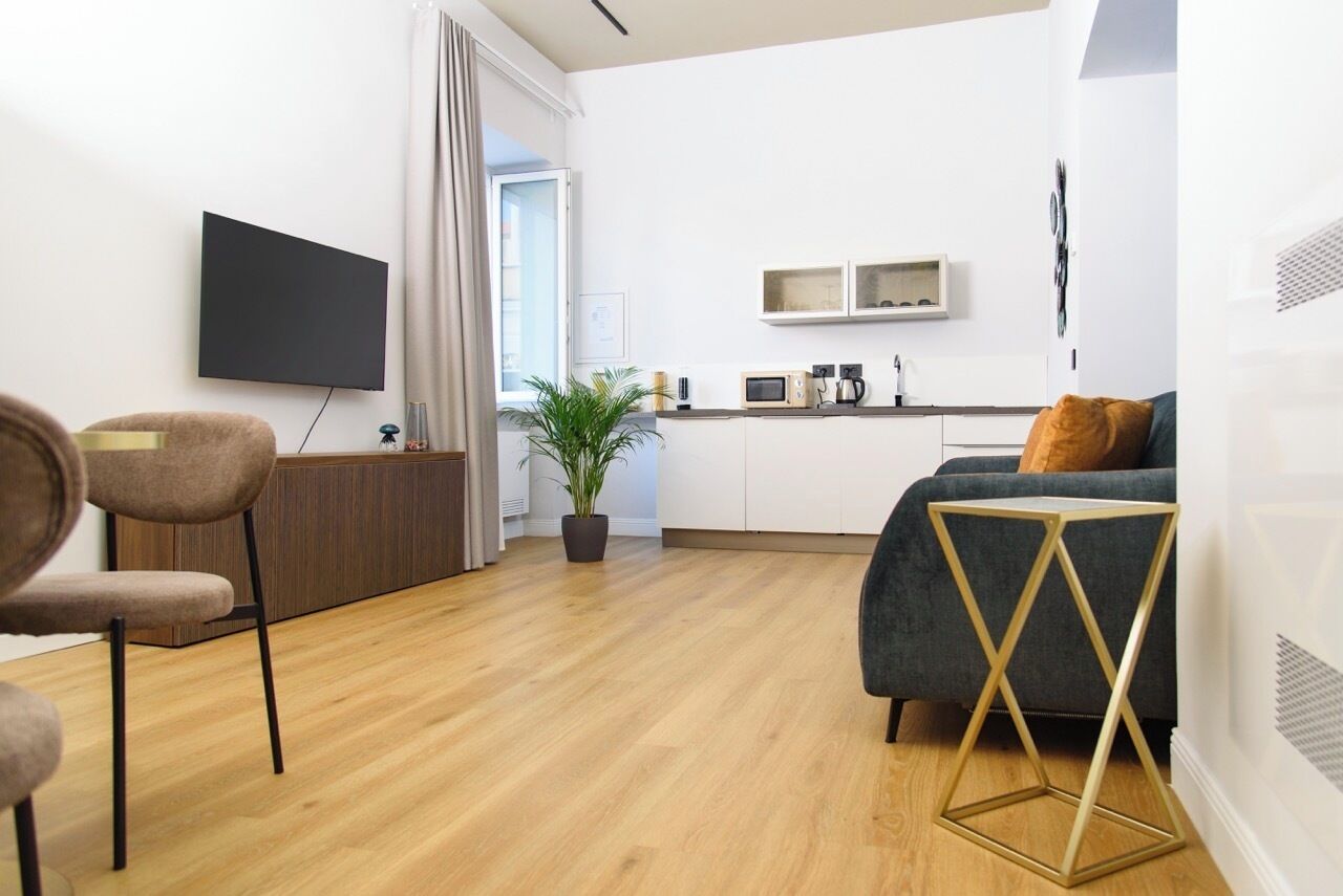 A modern living room with a sofa, a coffee table, and a TV mounted on the wall.