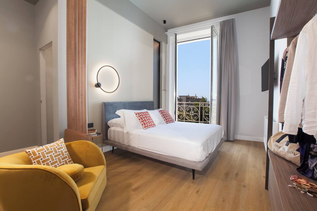 A modern bedroom with a bed, a sofa, and a wardrobe.