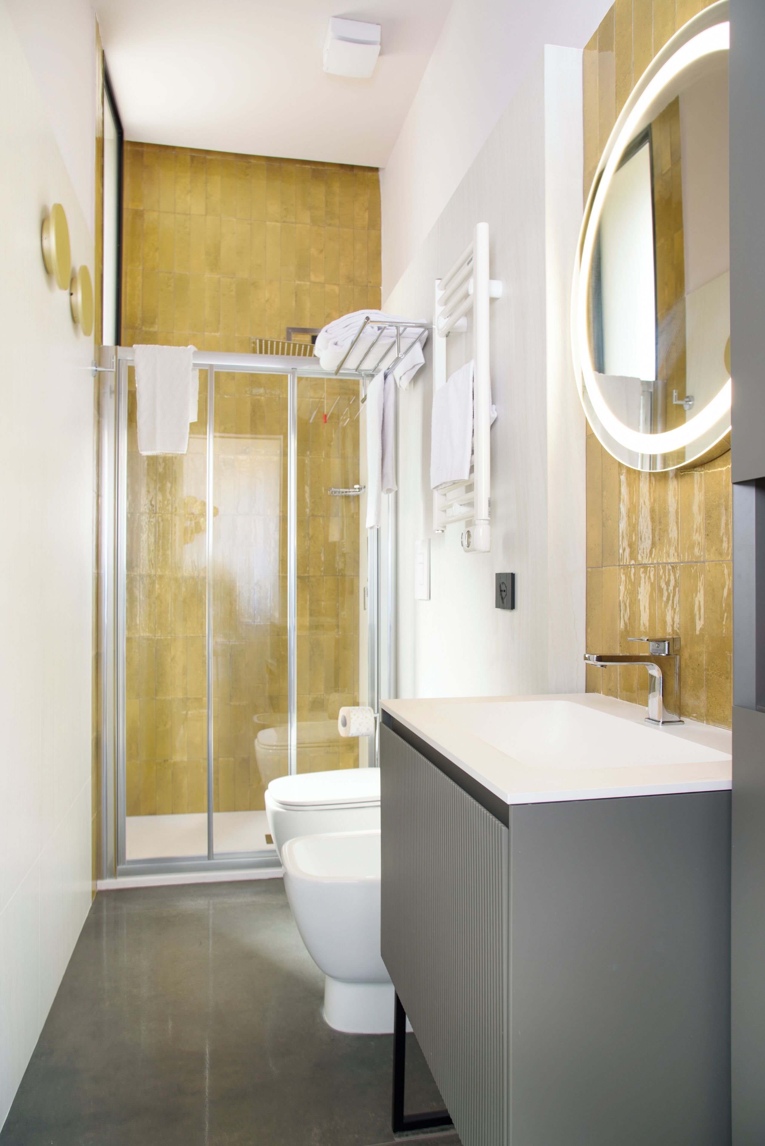 Une salle de bain moderne avec une douche à parois de verre, des toilettes blanches et un meuble-lavabo avec un miroir.