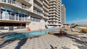 Ein Hotel mit Pool, Liegestühlen und einem Strandgeschäft.