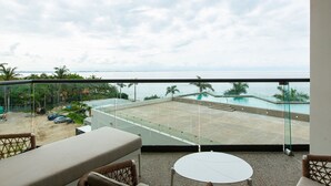 A balcony with a view of a swimming pool and the sea. - Beachfront Condo, Zantamar 205 (Cruz de Huanacaxtle)