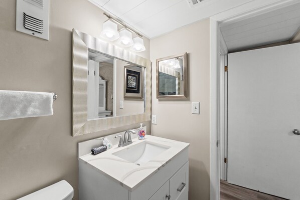 A bathroom with a double sink, a large mirror, and a towel rack.