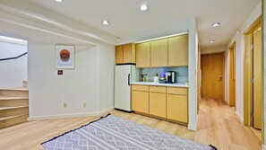 A modern kitchen with wooden cabinets, a refrigerator, and a coffee maker.