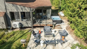 Une maison avec une terrasse, un espace salon extérieur et un jacuzzi.