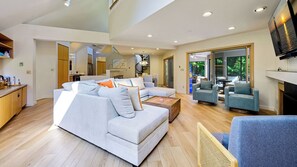 A spacious living room with a sectional sofa, a coffee table, and a fireplace. - Modern Home | Walk to Downtown, Hot Tub & GameRoom (Sister Bay)