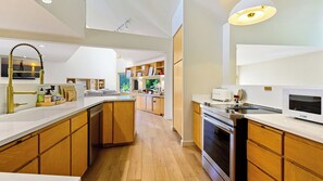 Une cuisine moderne avec des meubles en bois, un four encastré et un four à micro-ondes.