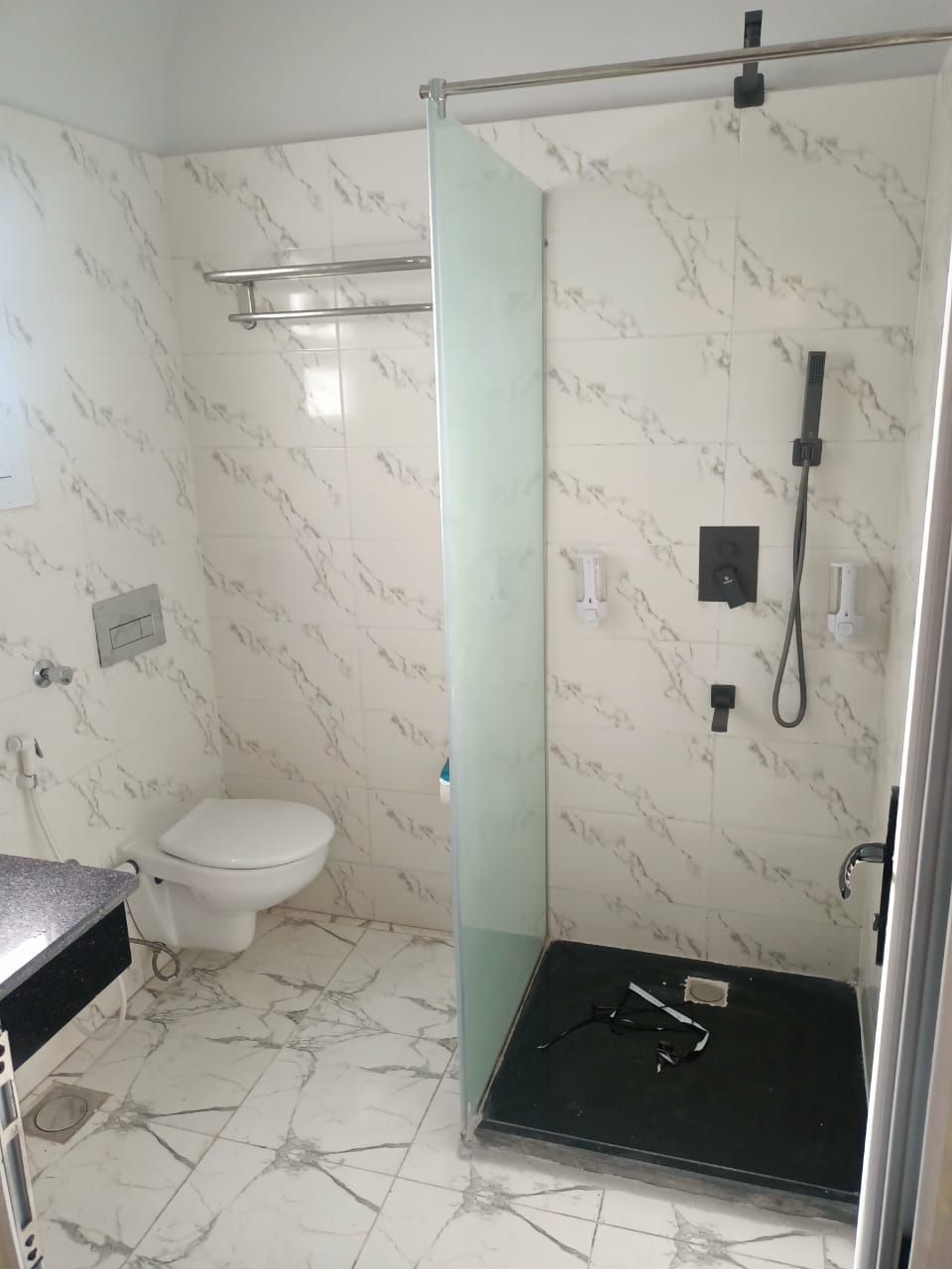 Une salle de bain avec douche, toilettes et lavabo.