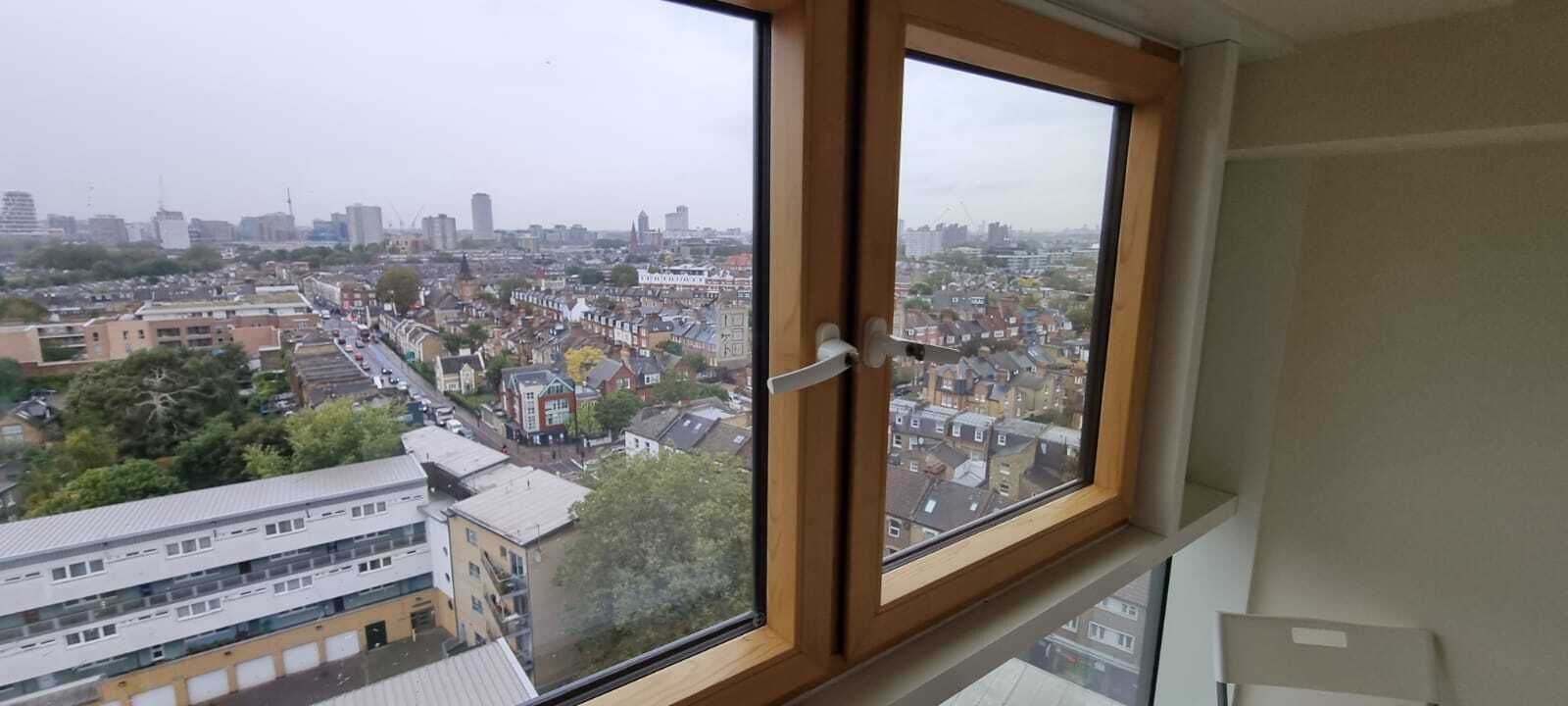 A high-rise building with a large window overlooking a cityscape.