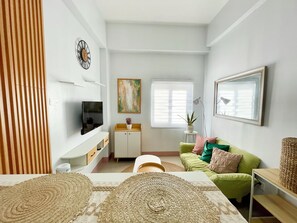 Relax in this stylish living room with a flat-screen TV, comfortable sofa, and a cozy reading nook.