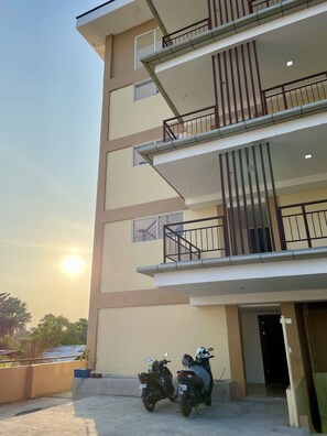Residential building with a flat roof and balcony, offering parking for guests.