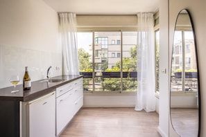 Een moderne keuken met een raam, een wijnfles en een glas.