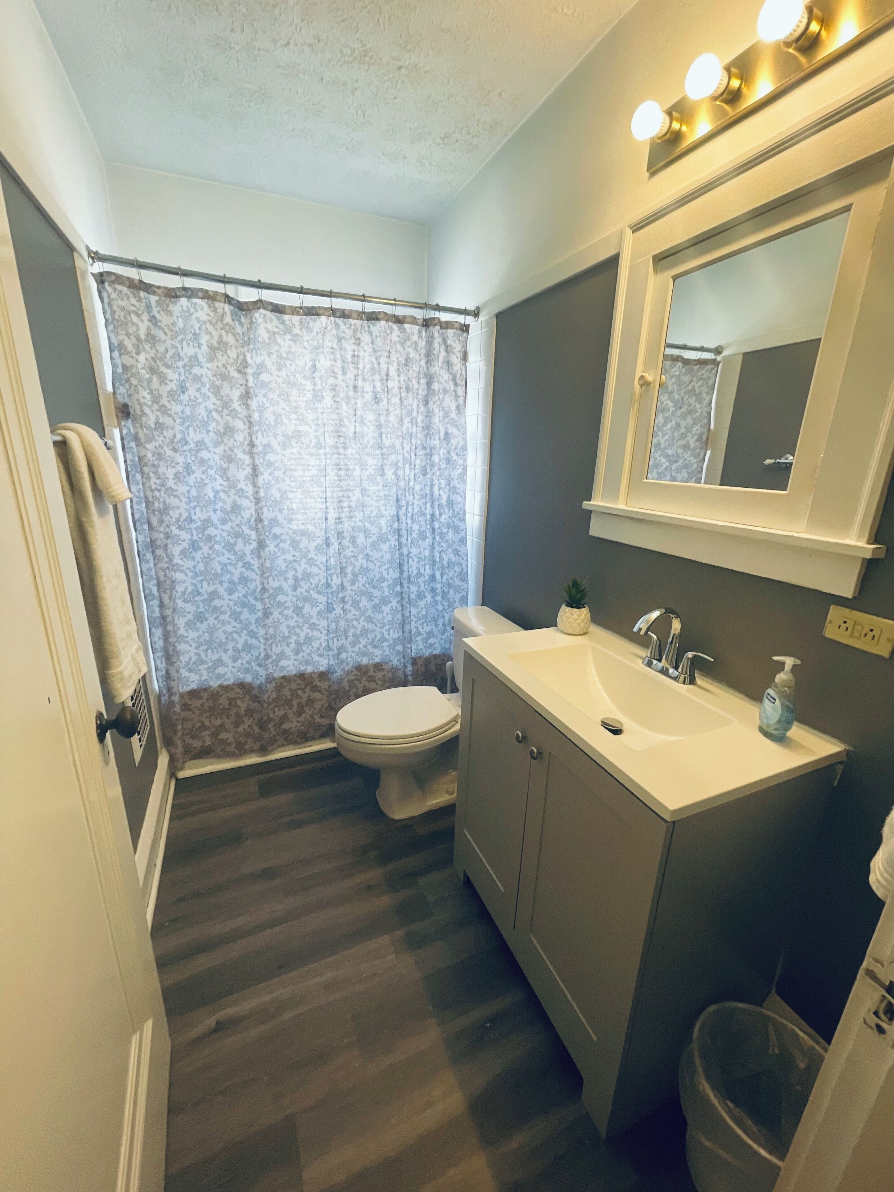 A bathroom with a toilet, sink, and mirror.