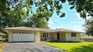 A single-story house with a garage, a front porch, and a well-maintained lawn. - Rockford Cascade Getaway (Rockford)