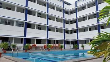 Relax by the pool in our central courtyard, surrounded by lush greenery and comfortable seating.