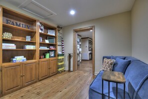 A cozy living area with a blue sofa, a small wooden table, and a bookshelf labeled 'FAMILY'.
