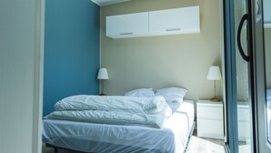 Une chambre à coucher avec un lit, des tables de chevet et une fenêtre.