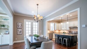 A spacious kitchen with a central island, white cabinetry, and pendant lighting. - The Reed Retreat, 4BR Luxe by Velvet Ditch Villas (Oxford)
