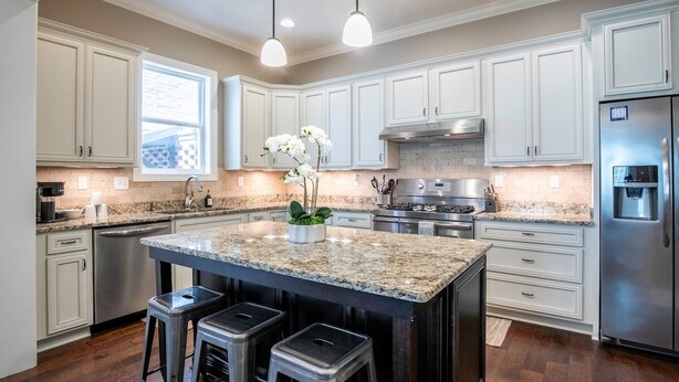 A modern kitchen with white cabinets, a granite island, stainless steel appliances, and pendant lighting. - The Reed Retreat, 4BR Luxe by Velvet Ditch Villas (Oxford)
