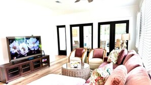 A living room with a television, sofa, chairs, and a coffee table. - 2 Primary Kings! Screened Porch! EV Charger! (Bay Saint Louis)
