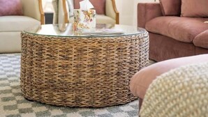 A cozy living room with a round wicker coffee table, a beige sofa, and a pink sofa with matching cushions. - 2 Primary Kings! Screened Porch! EV Charger! (Bay Saint Louis)