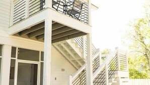 A two-story house with a balcony, a staircase, and a porch. - 2 Primary Kings! Screened Porch! EV Charger! (Bay Saint Louis)
