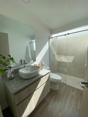 Standaard huis, uitzicht op tuin | Badkamer | Een douche, handdoeken, zeep, toiletpapier